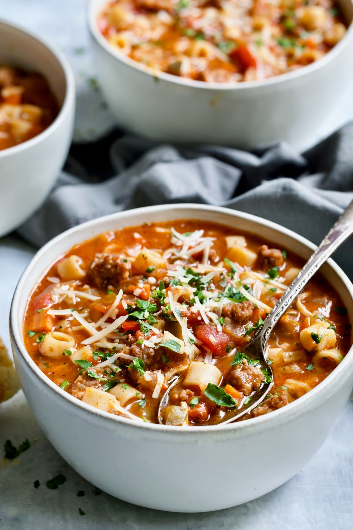Italian Sausage Soup in white bowl with spoon.