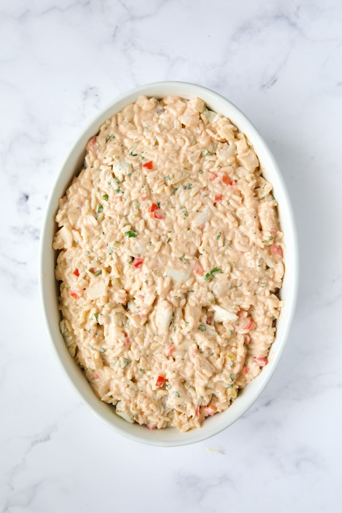 Assembled casserole in white baking dish without topping.