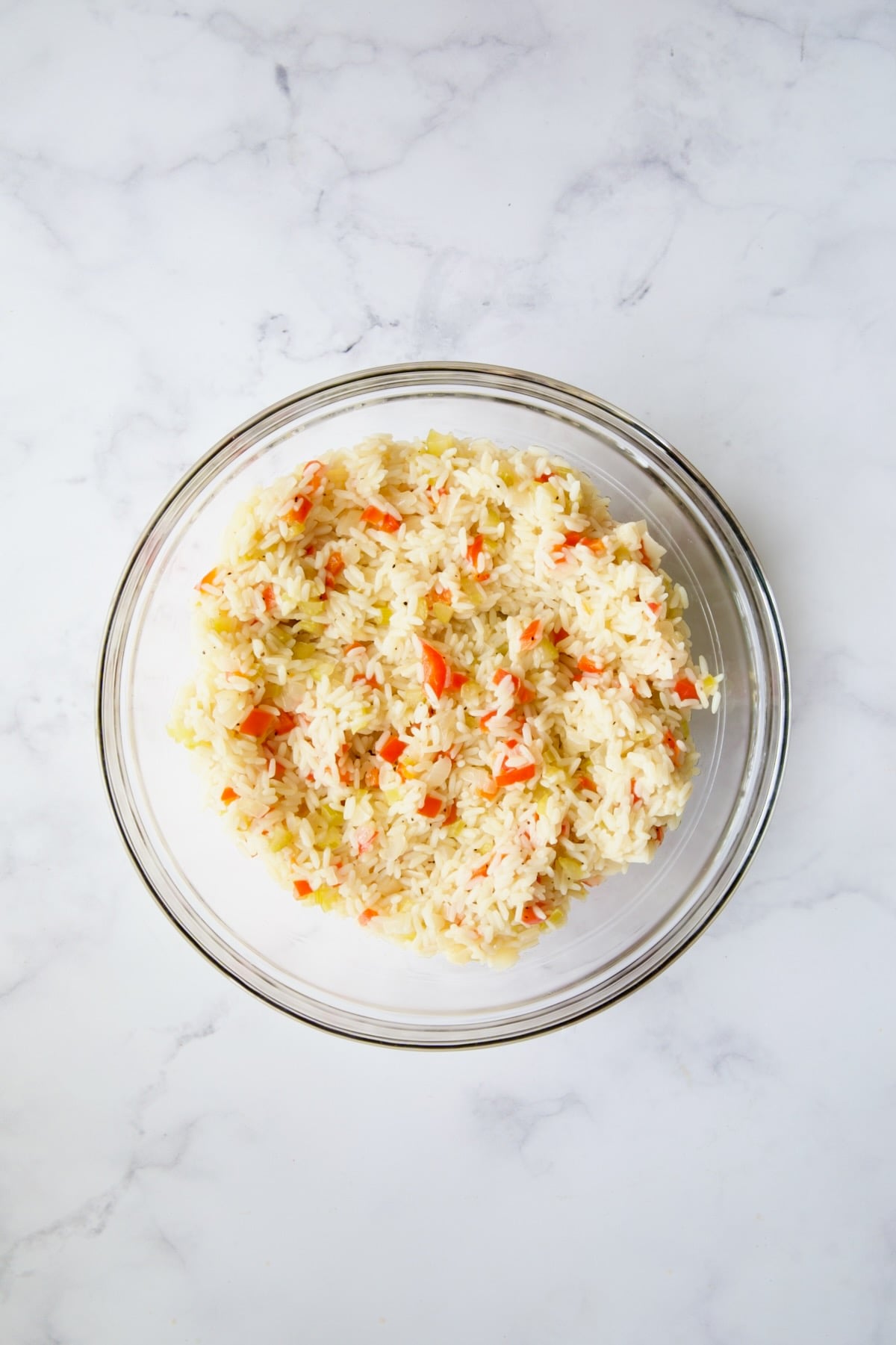 Cooked rice and vegetables in glass bowl.