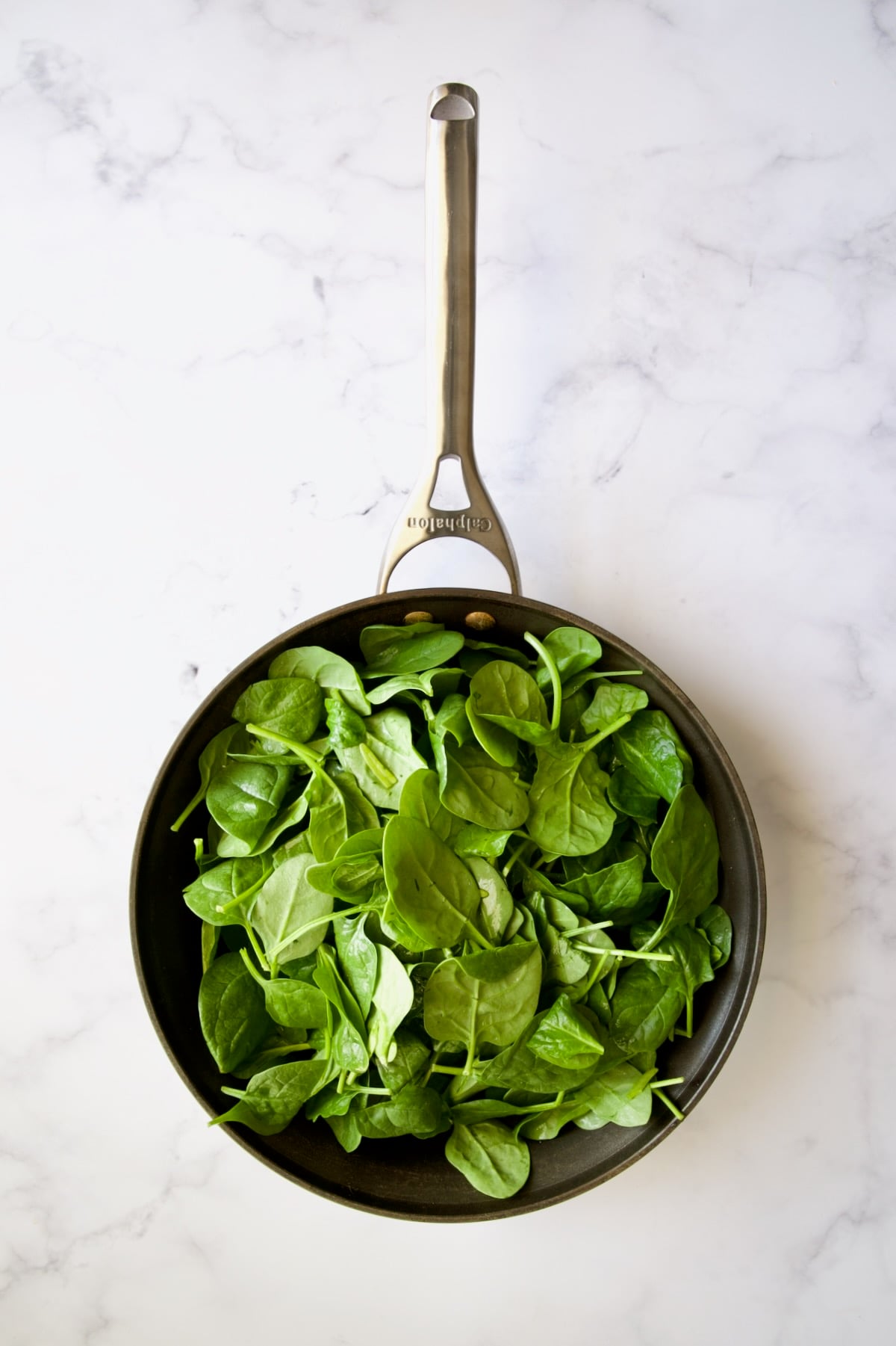 Fresh unwilted baby spinach in nonstick skillet.