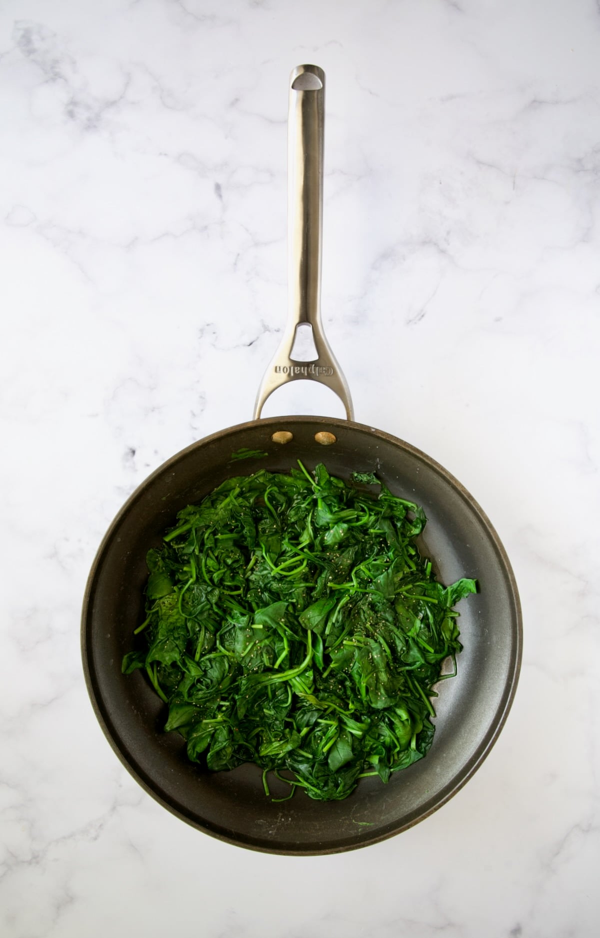 Wilted baby spinach in nonstick skillet.