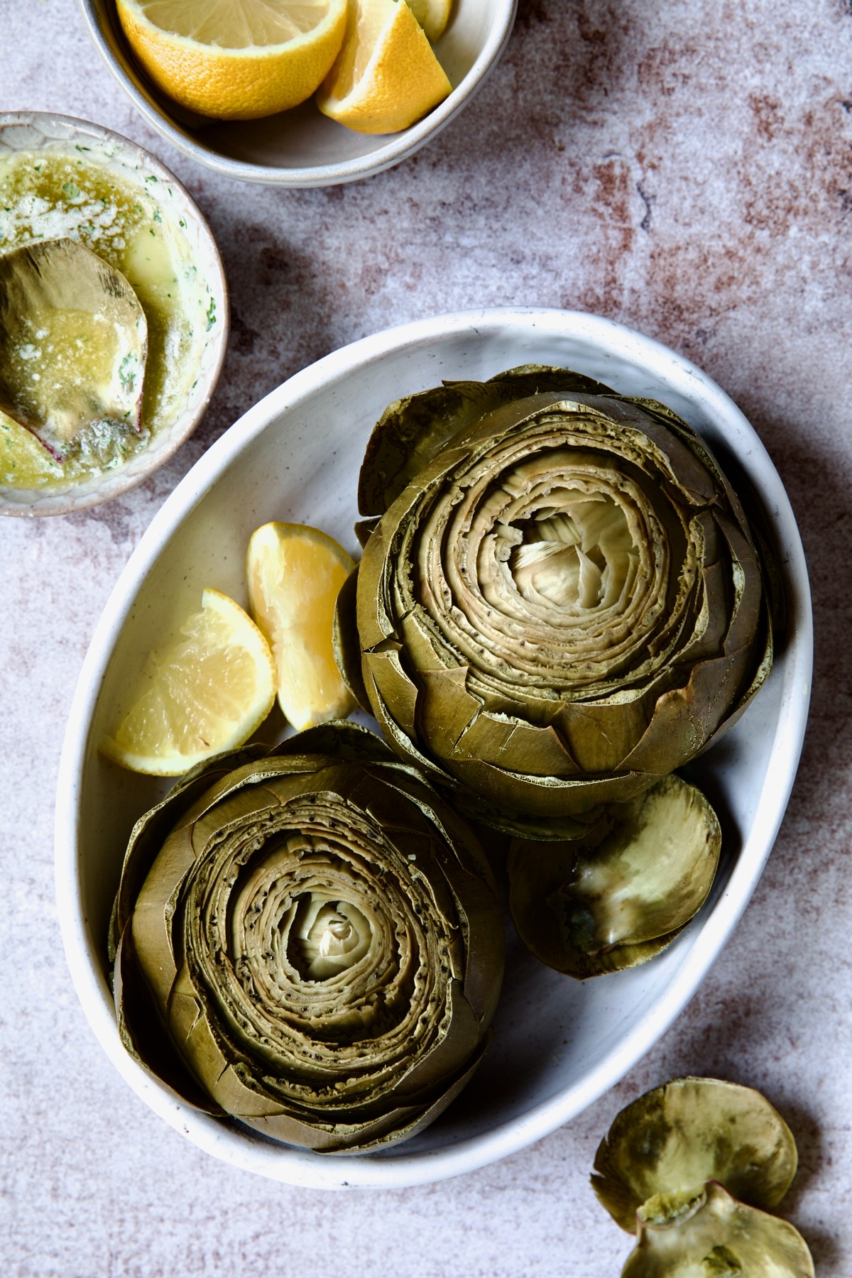 Instant Pot Artichokes (With Garlic Butter) with lemon wedges.