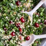 Kale Quinoa Salad with Lemon Honey Dressing in gray serving bowl with serving utensils.