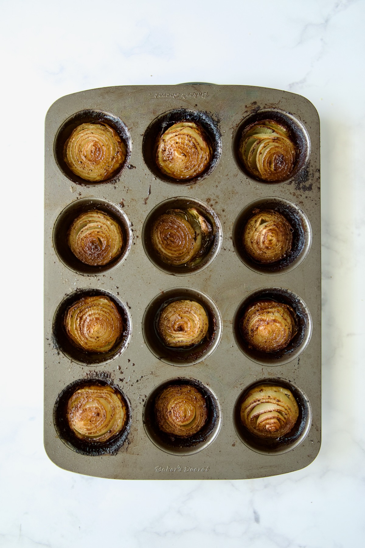 Roasted Onions in nonstick muffin pan after being baked for one hour.