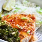 Sheet Pan Thai Baked Fish with Broccolini on white plate with fork.