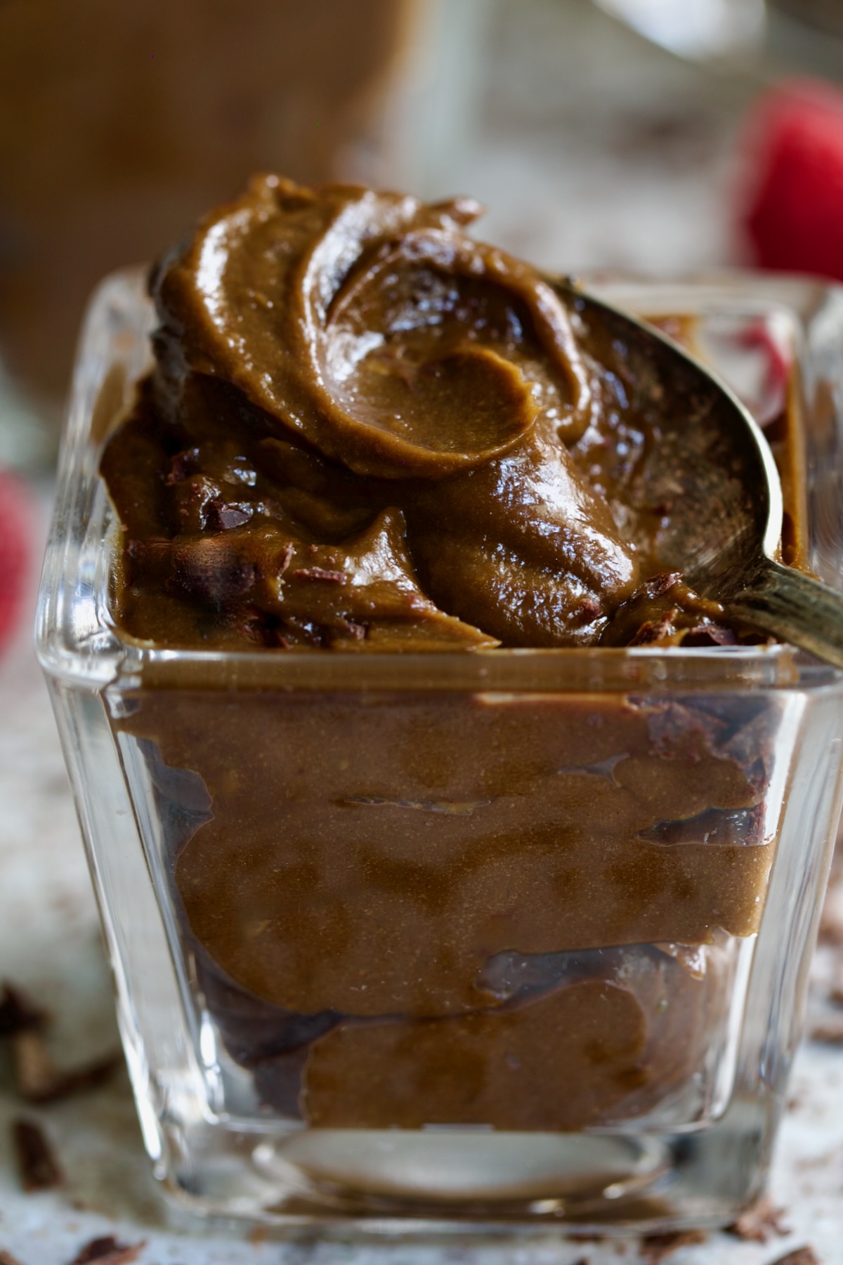 Spoon lifting some of the mousse from square dessert glass.
