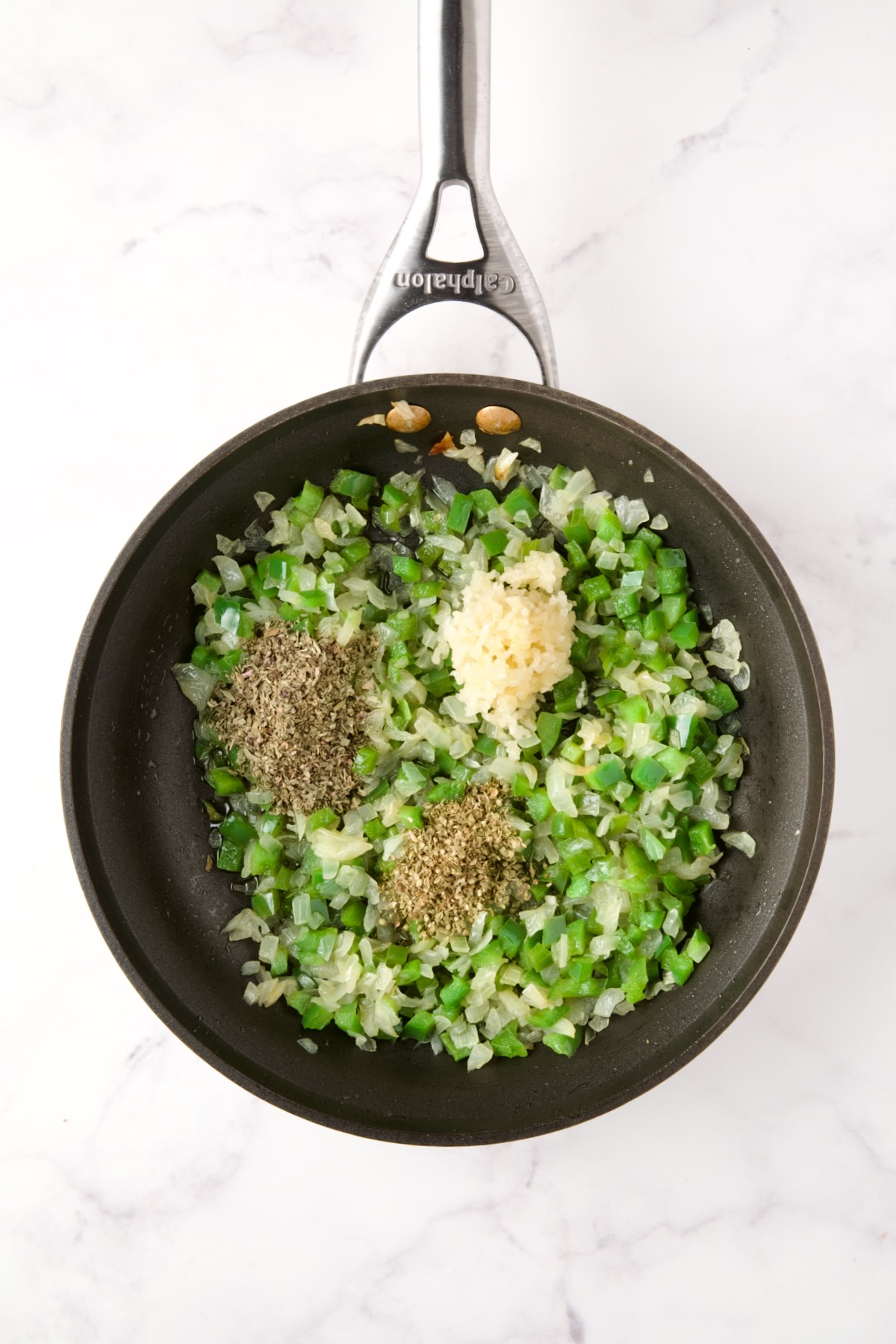 Cooked onions and green peppers in nonstick skillet with dried herbs and garlic added.
