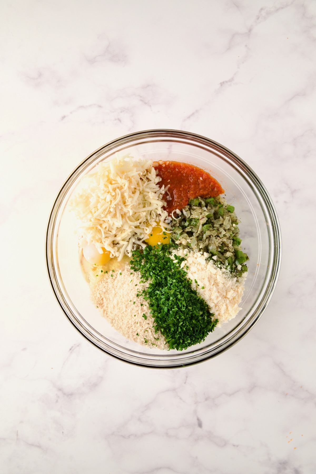 Ingredients for meatloaf in glass bowl before being mixed together.