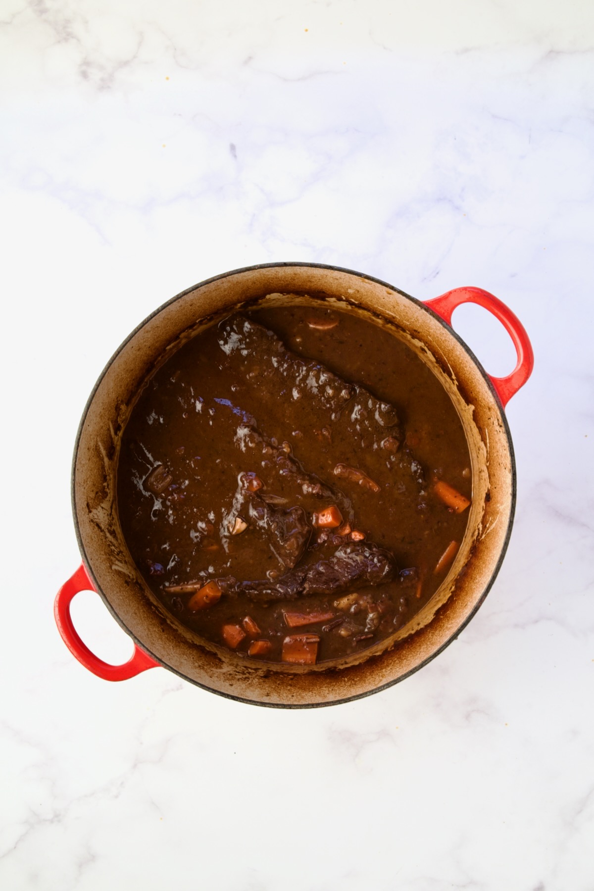 Thickened recipe in red Dutch oven.