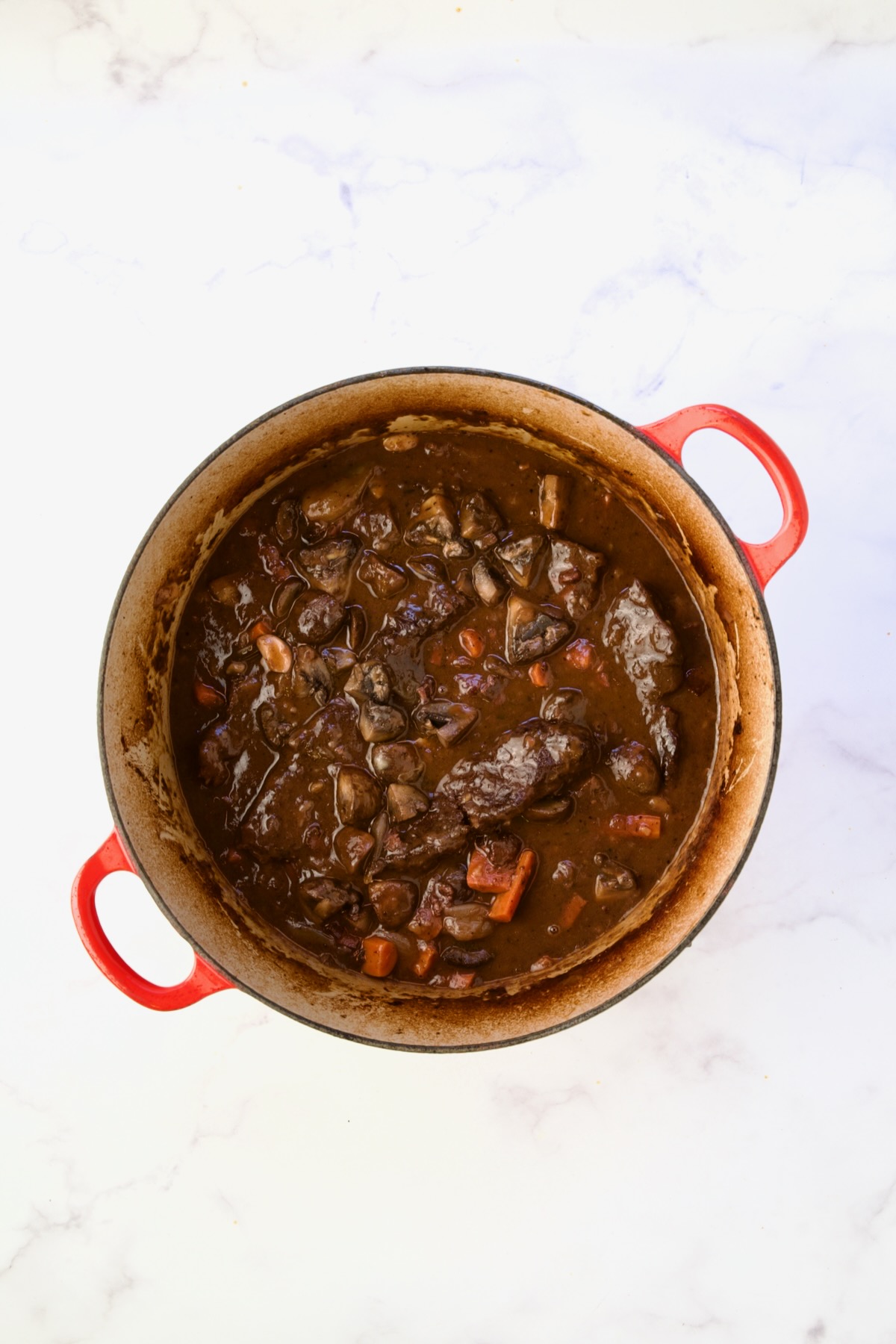 Finished Short Ribs Bourguignon in red Dutch oven.