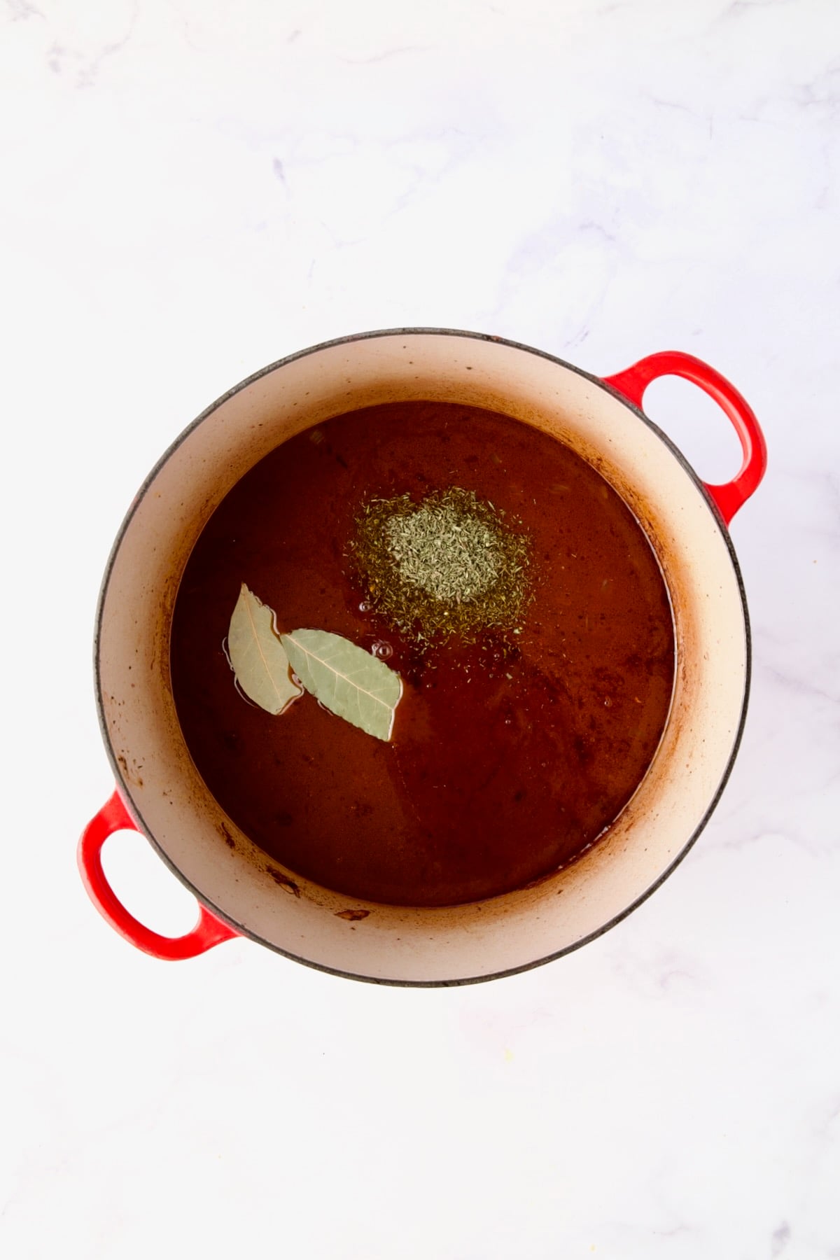 Recipe with dried herbs added before being braised in red Dutch oven.