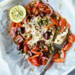 Mediterranean Fish en Papillote opened to reveal baked fish with a piece of the fish on a fork.