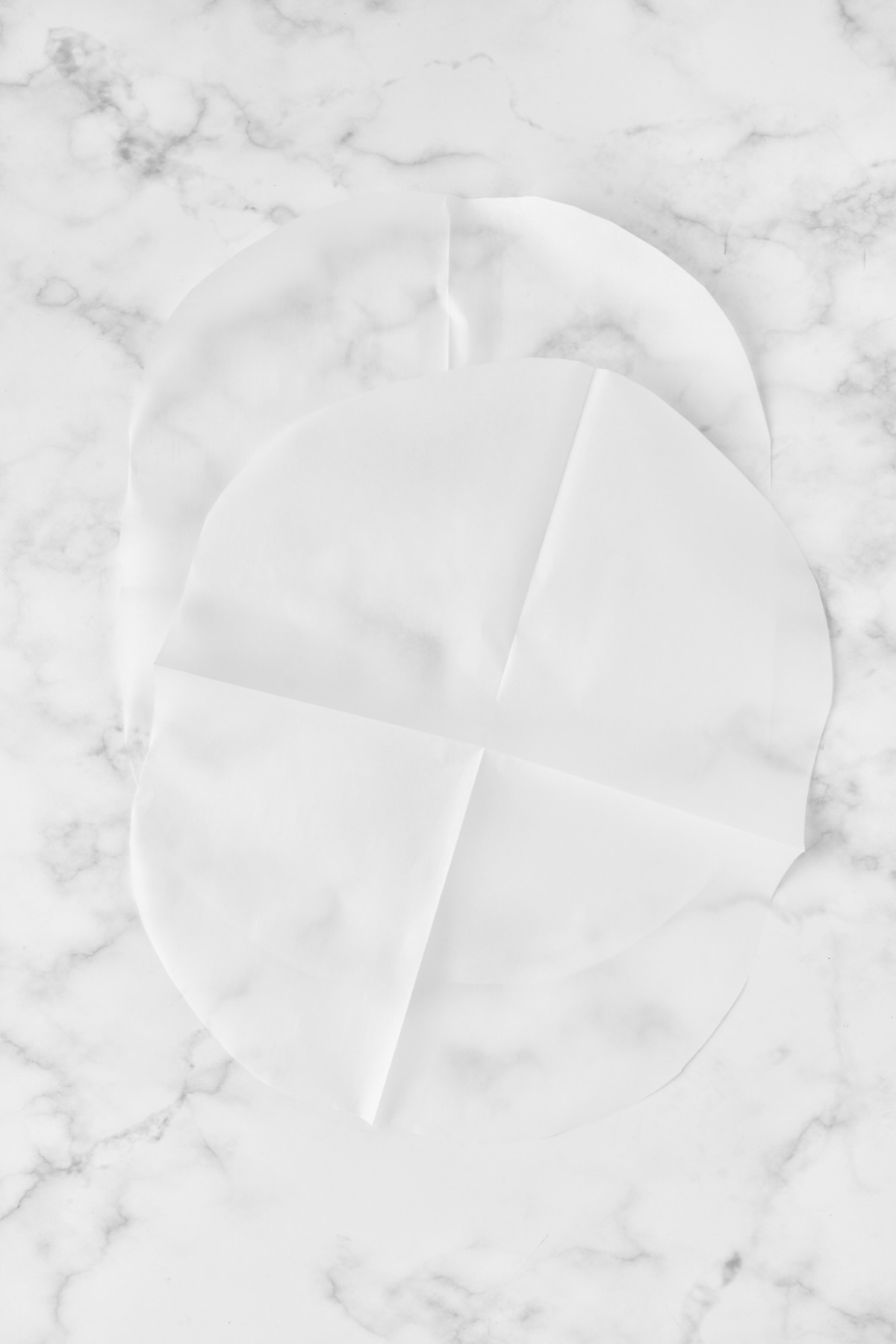 Two pieces of parchment paper cut into large ovals.