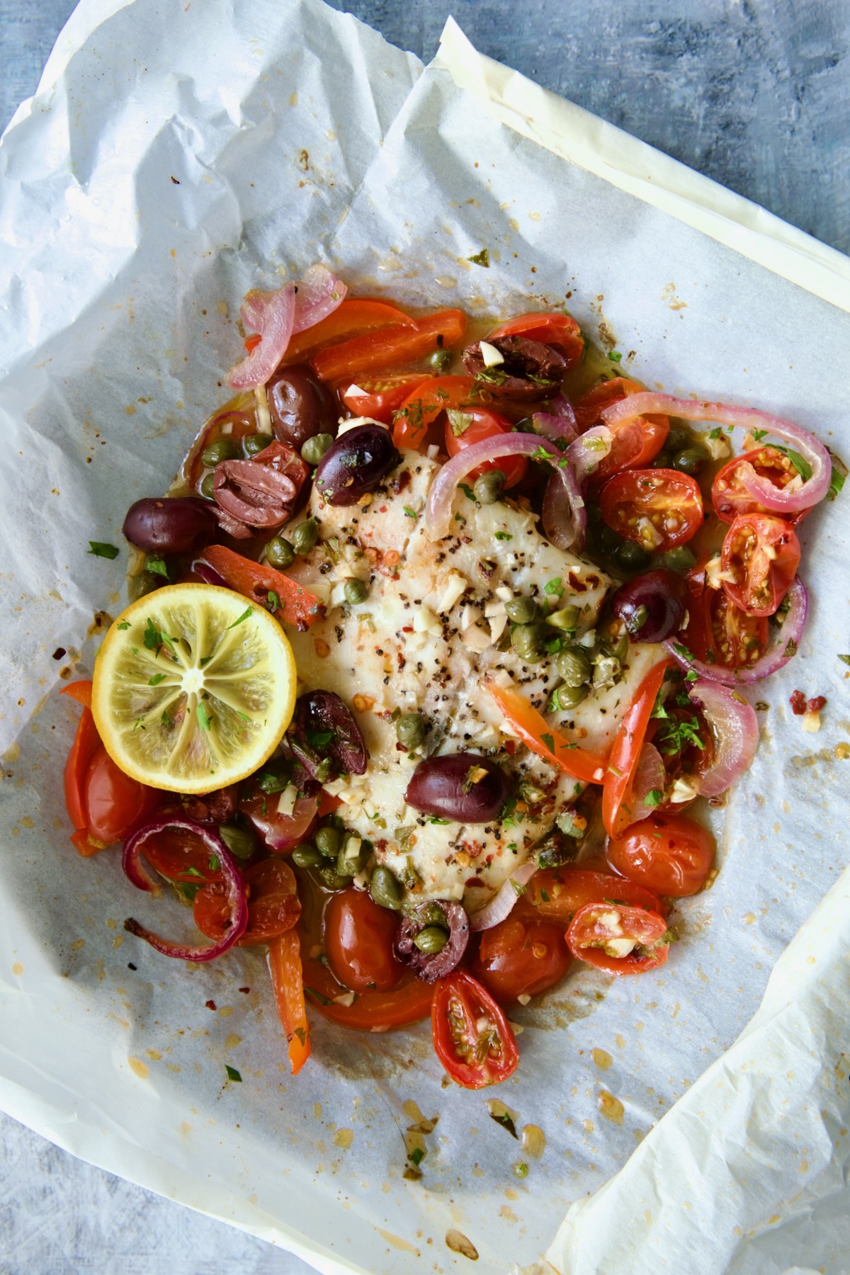 Baked Mediterranean Fish en Papillote on parchment paper.
