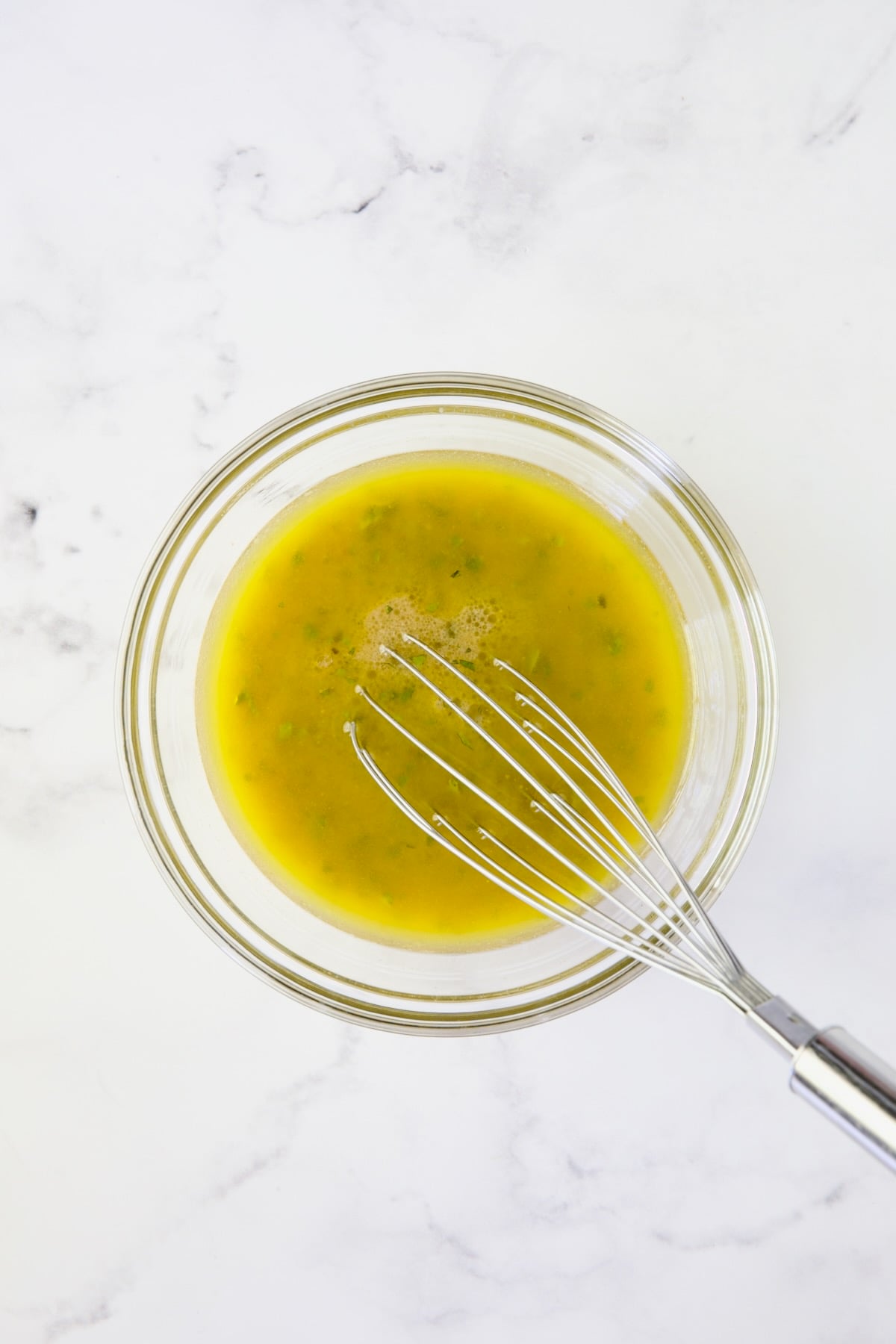 Vinaigrette being whisked with wire whisk.