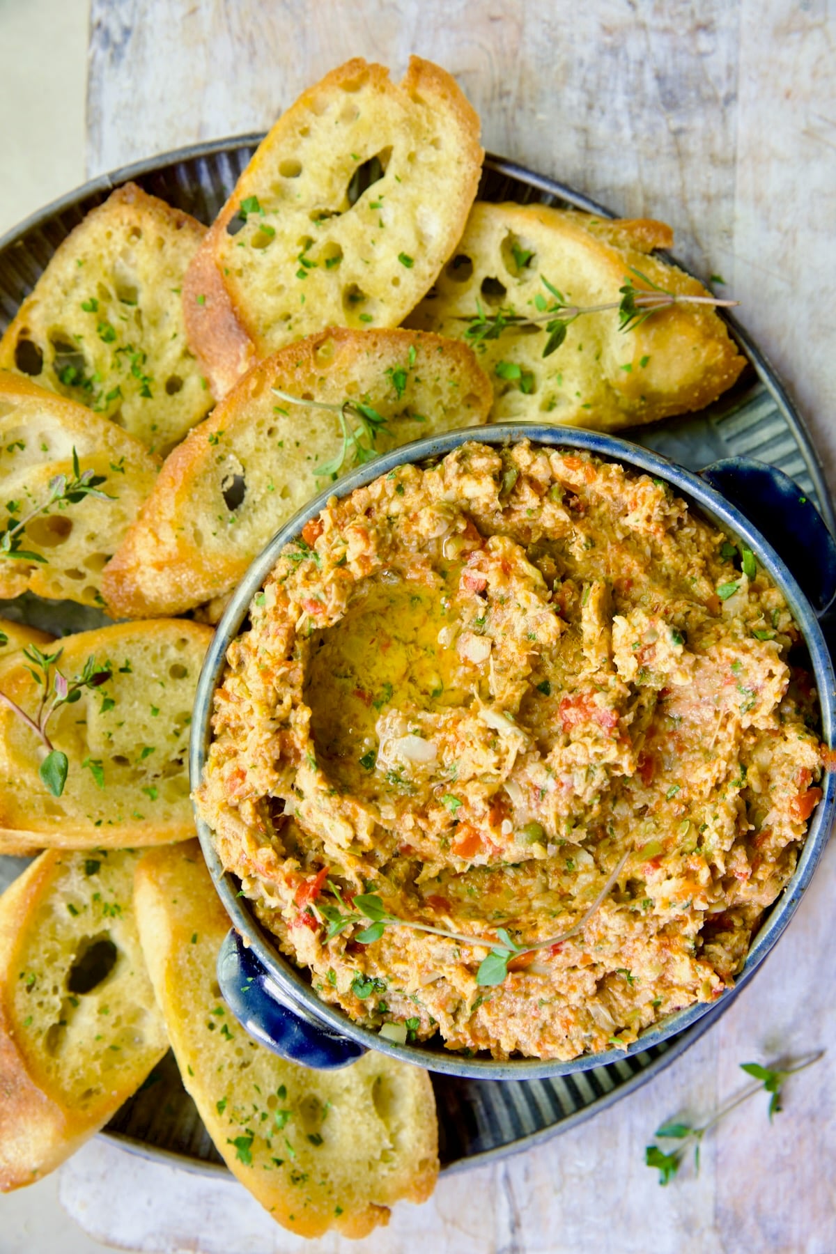 Artichoke Tapenade with Crostini on metal platter.