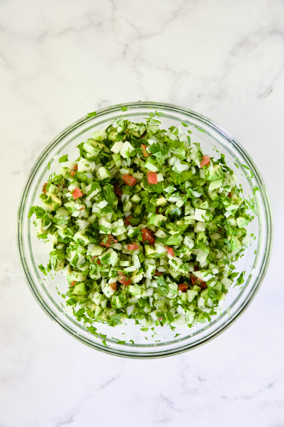 Vegetables in glass bowl after being stirred.