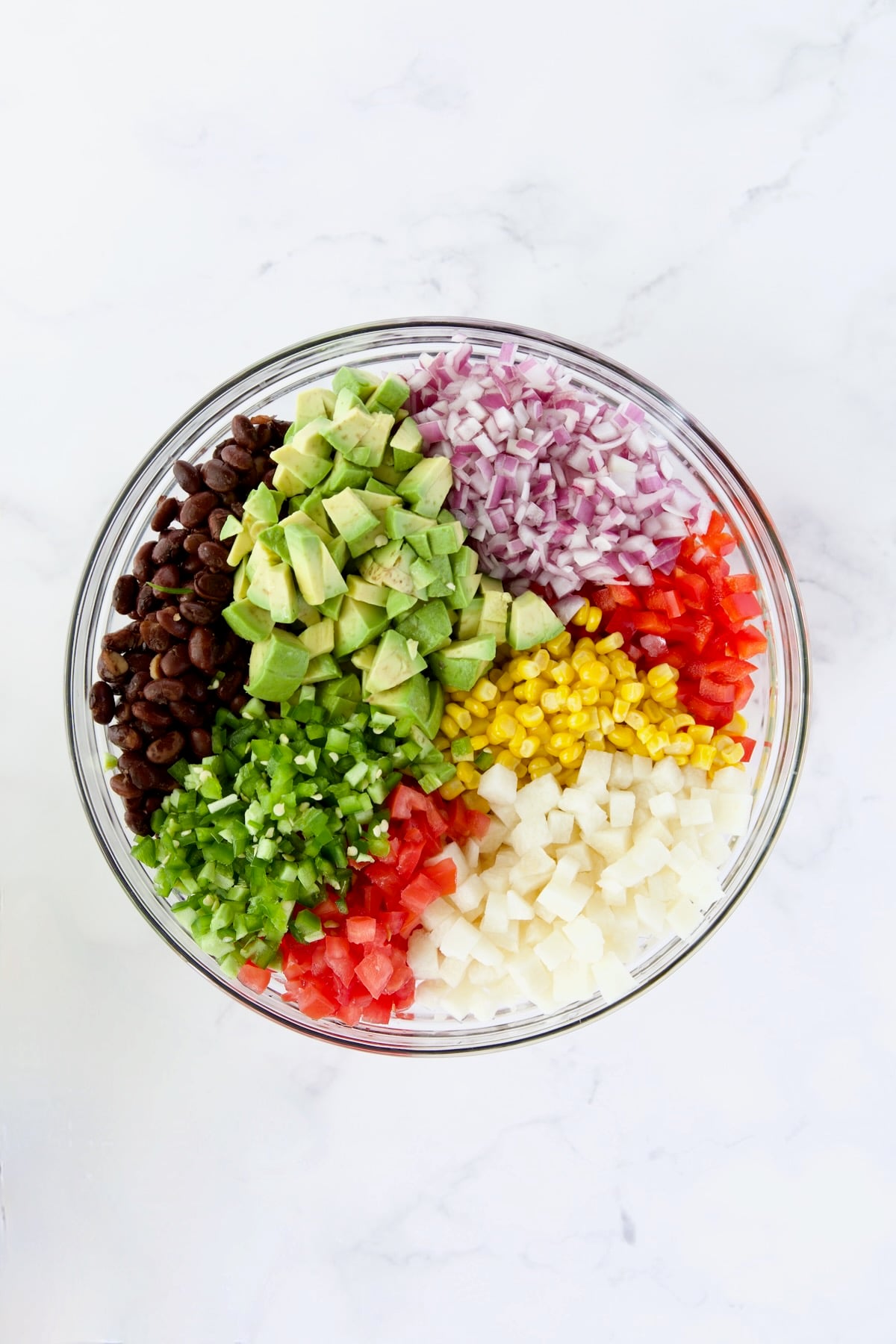Ingredients for Southwestern Salad in glass bowl before being stirred together.