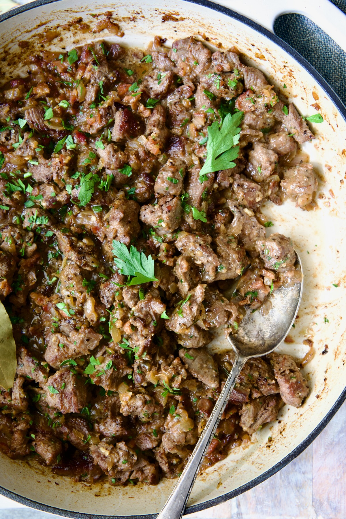 Beef Tips in Beer Sauce in white enamel cast iron skillet.