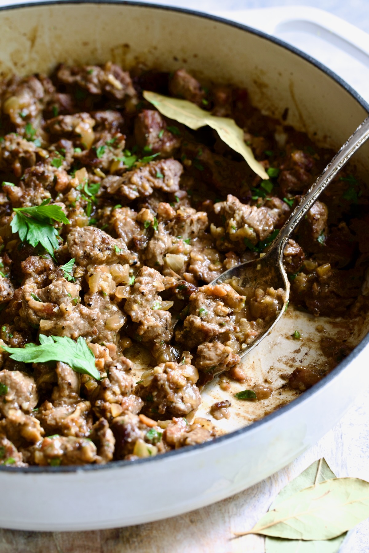 Beef Tips in Beer Sauce in white enamel cast iron skillet.