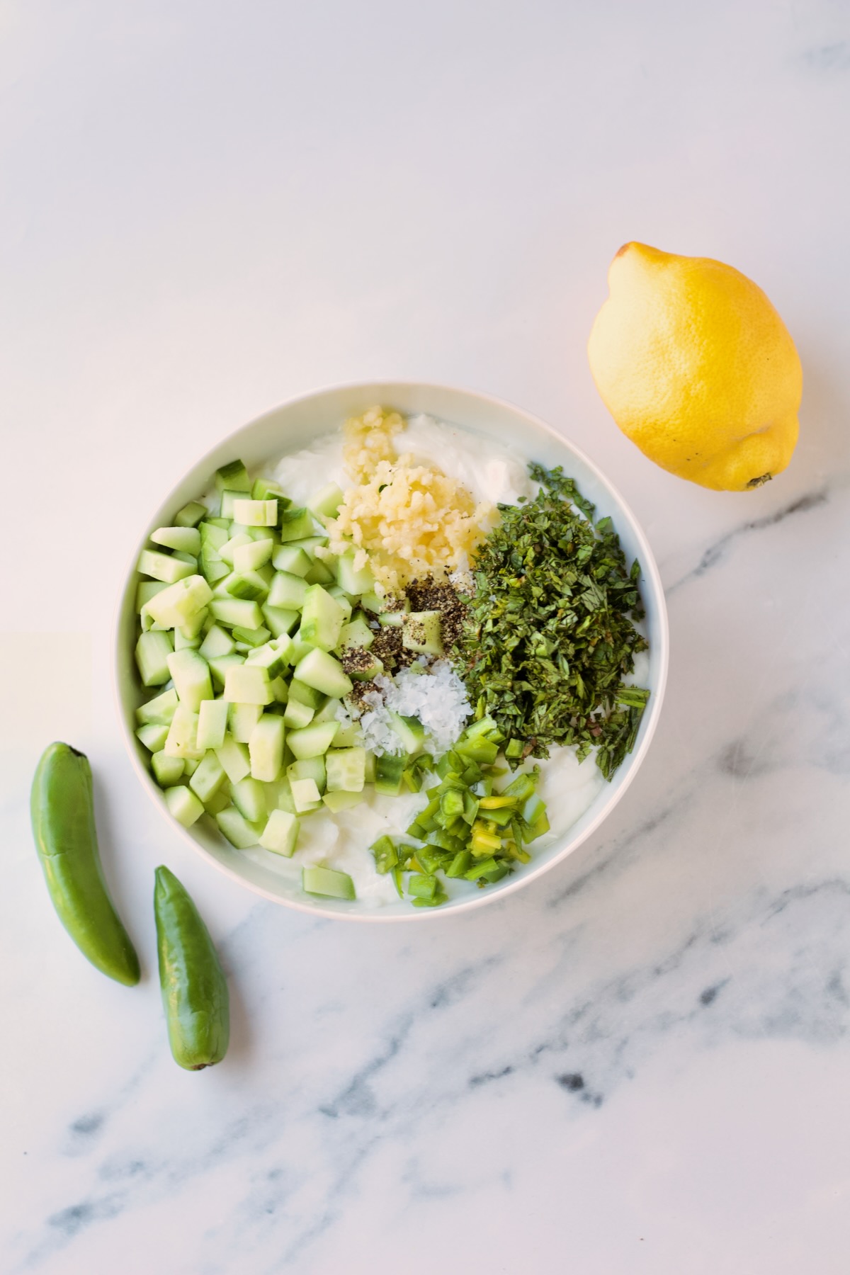 Ingredients for tzatziki in bowl on countertop.