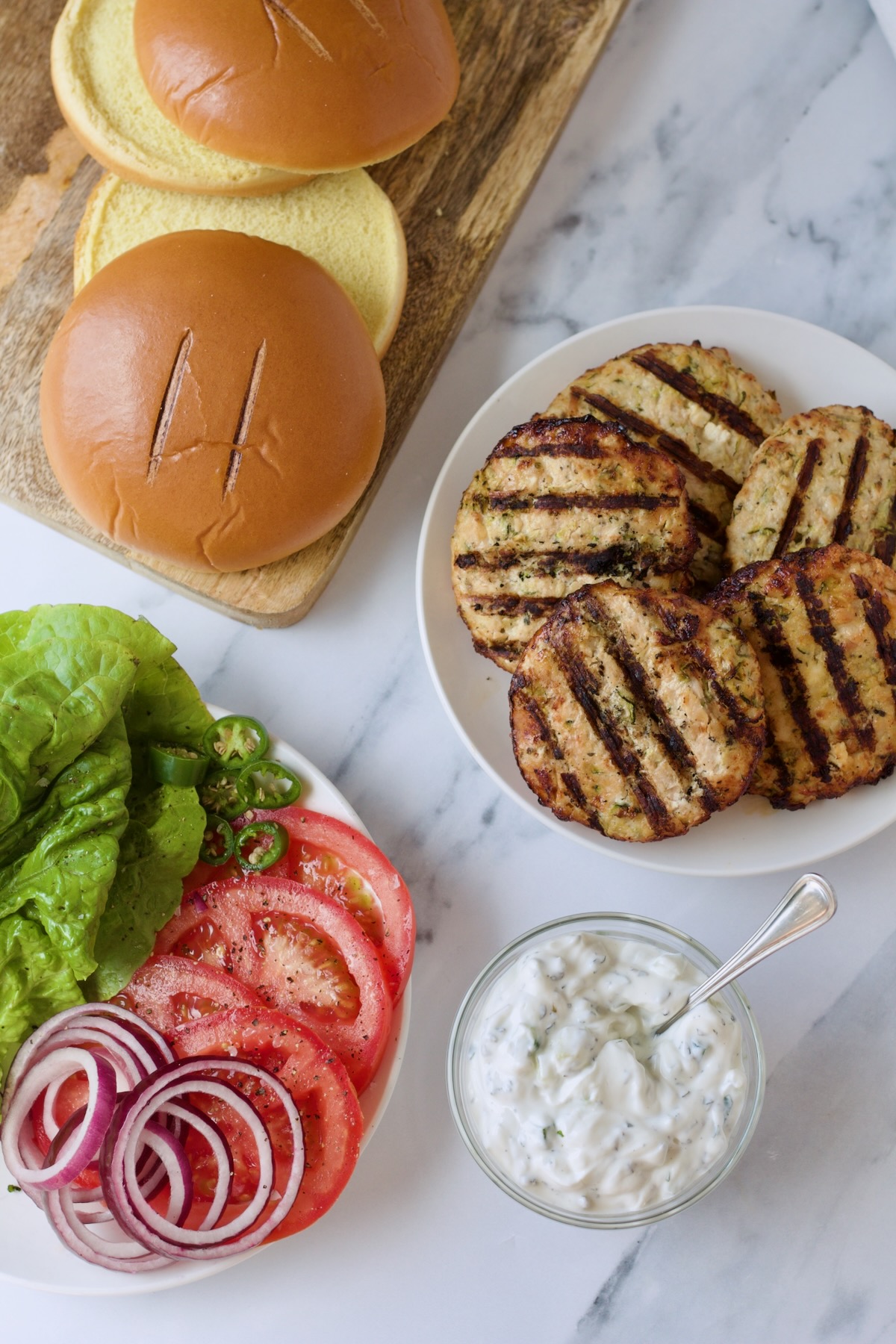 Ingredients for Ground Chicken Burgers with Spicy Tzatziki ready to be assembled.