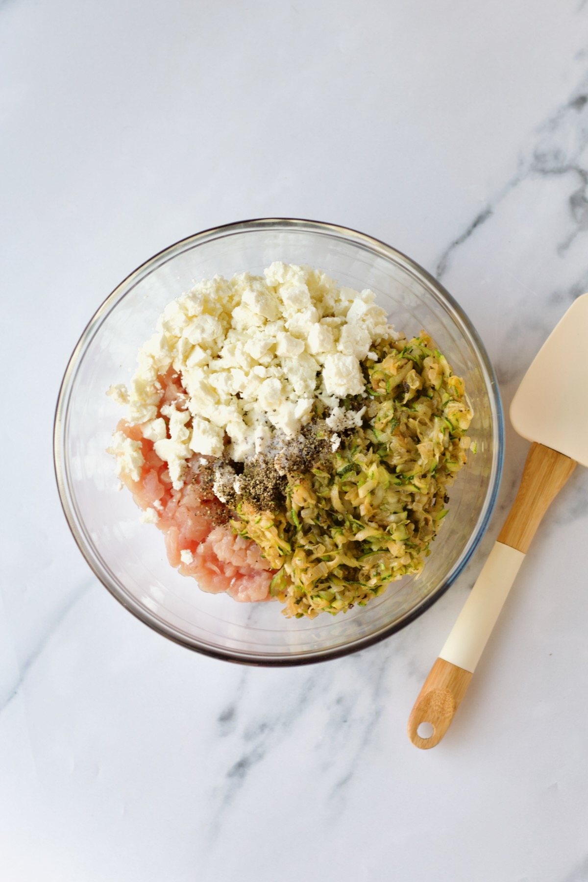 Ingredients for chicken burgers in glass bowl.