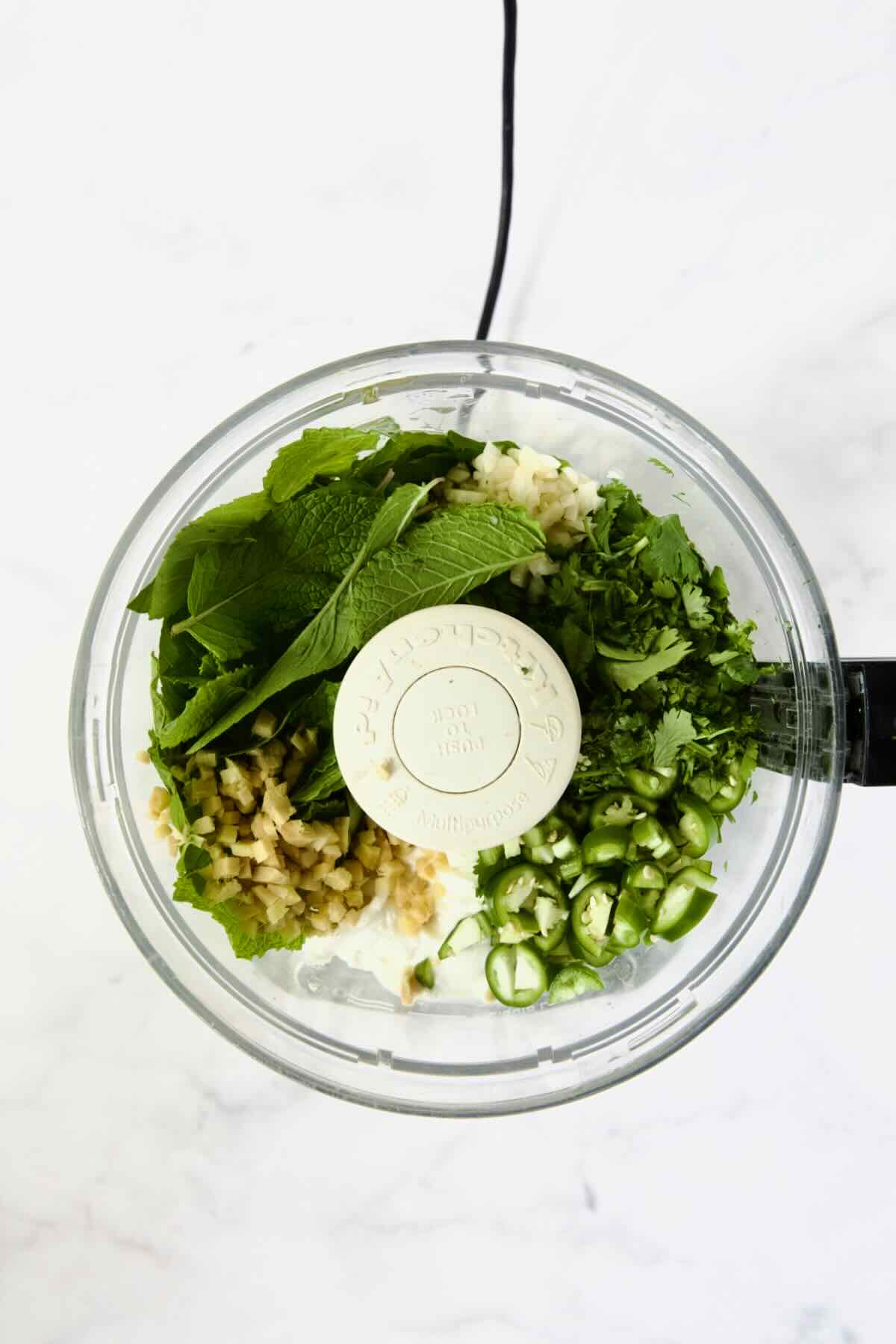 Ingredients for Cilantro Mint Chutney in food processor before being pureed.