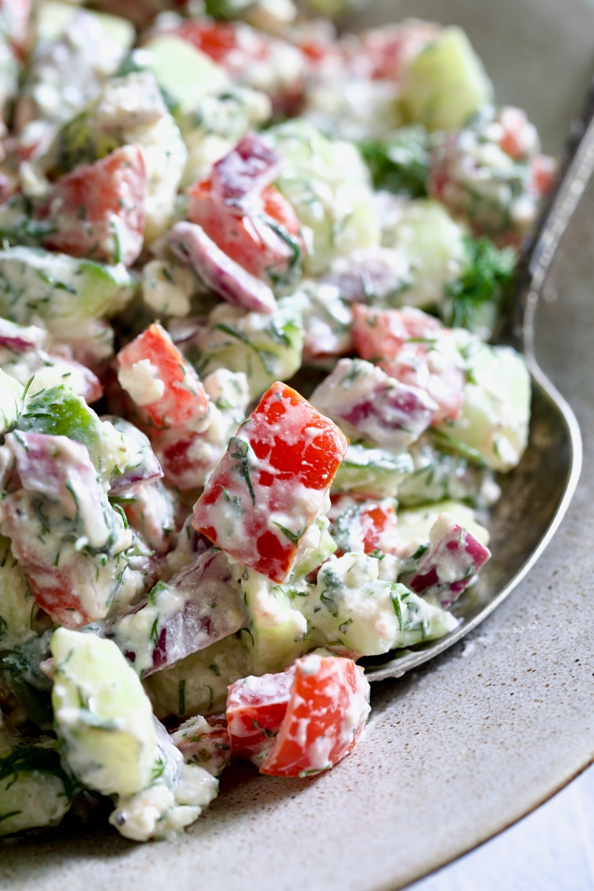 Cucumber Tomato Feta Salad with serving spoon.