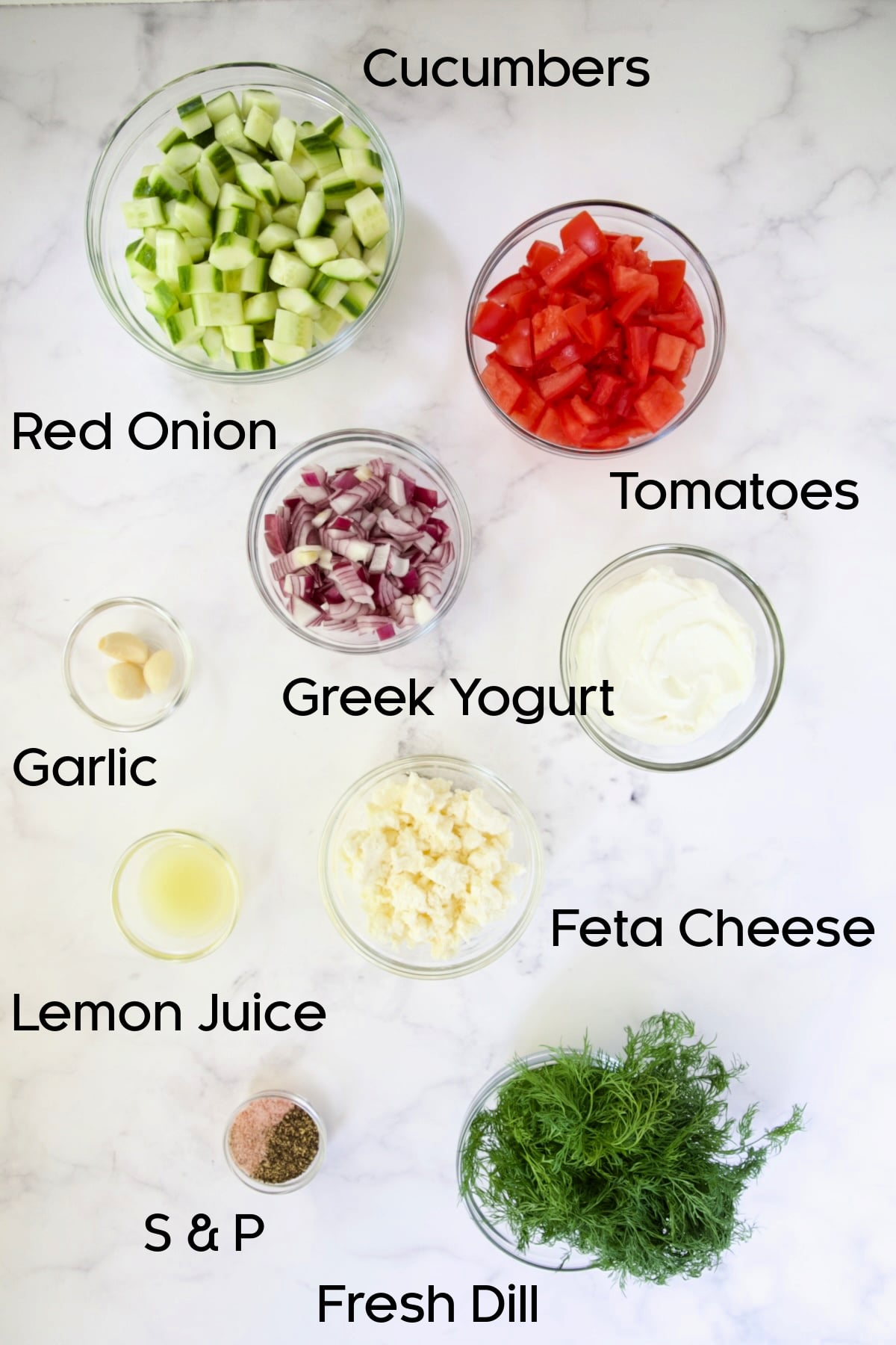 Ingredients for Cucumber Tomato Feta Salad in glass bowls.