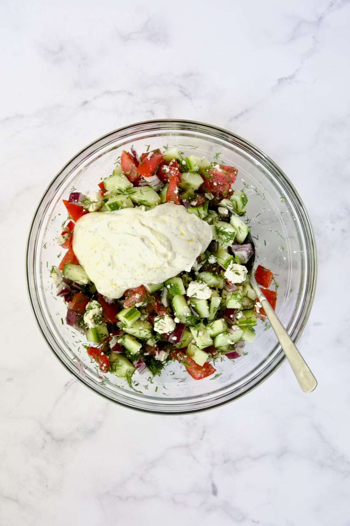 Ingredients for Cucumber Tomato Feta Salad with yogurt dressing added.
