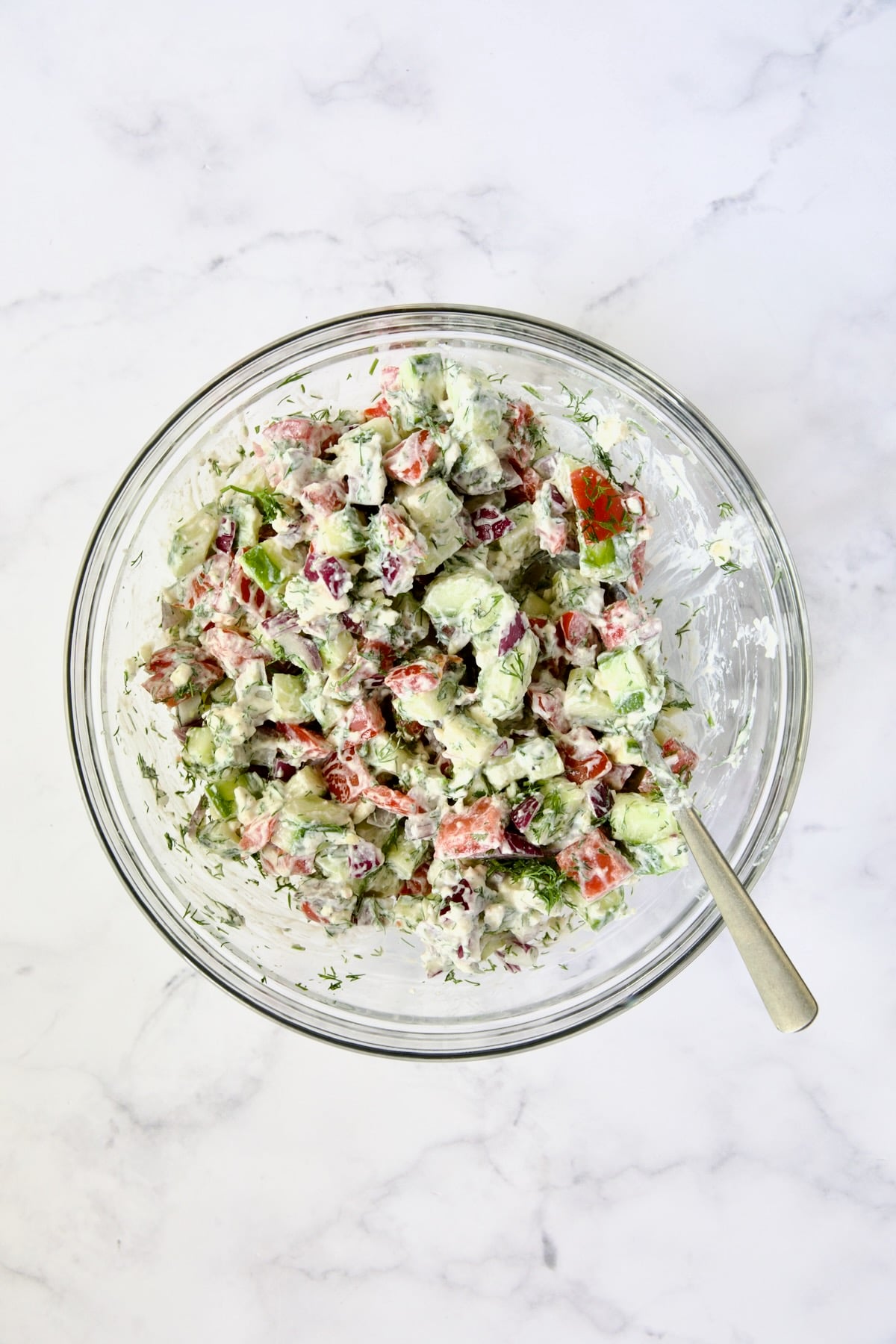 Cucumber Tomato Feta Salad mixed together in glass bowl.