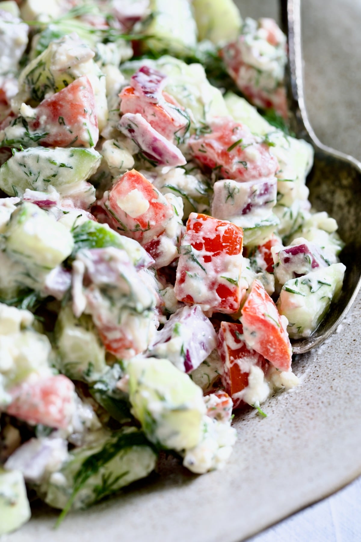 Cucumber Tomato Feta Salad with serving spoon.