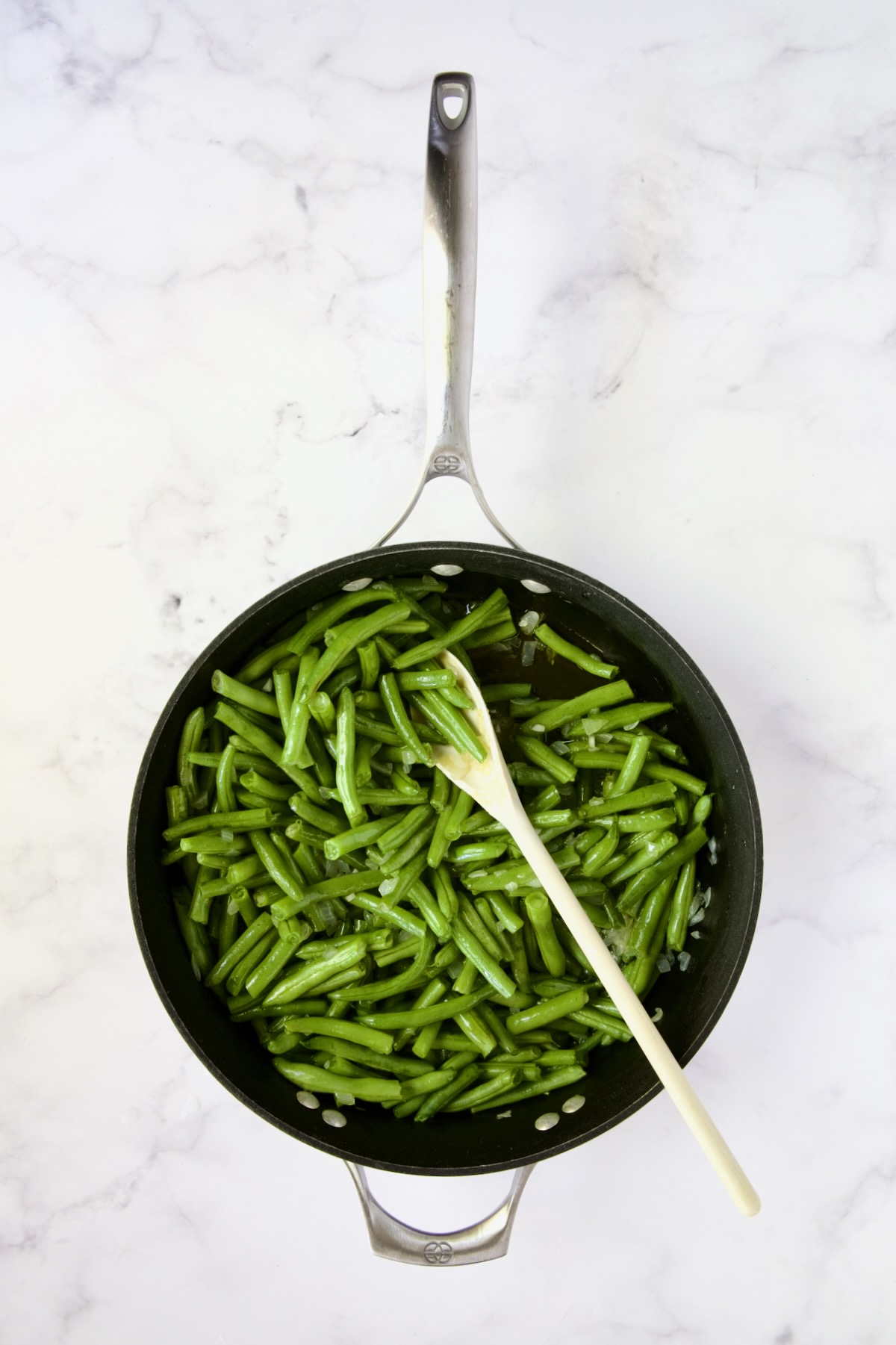 Green beans being sauteed in nonstick skillet.