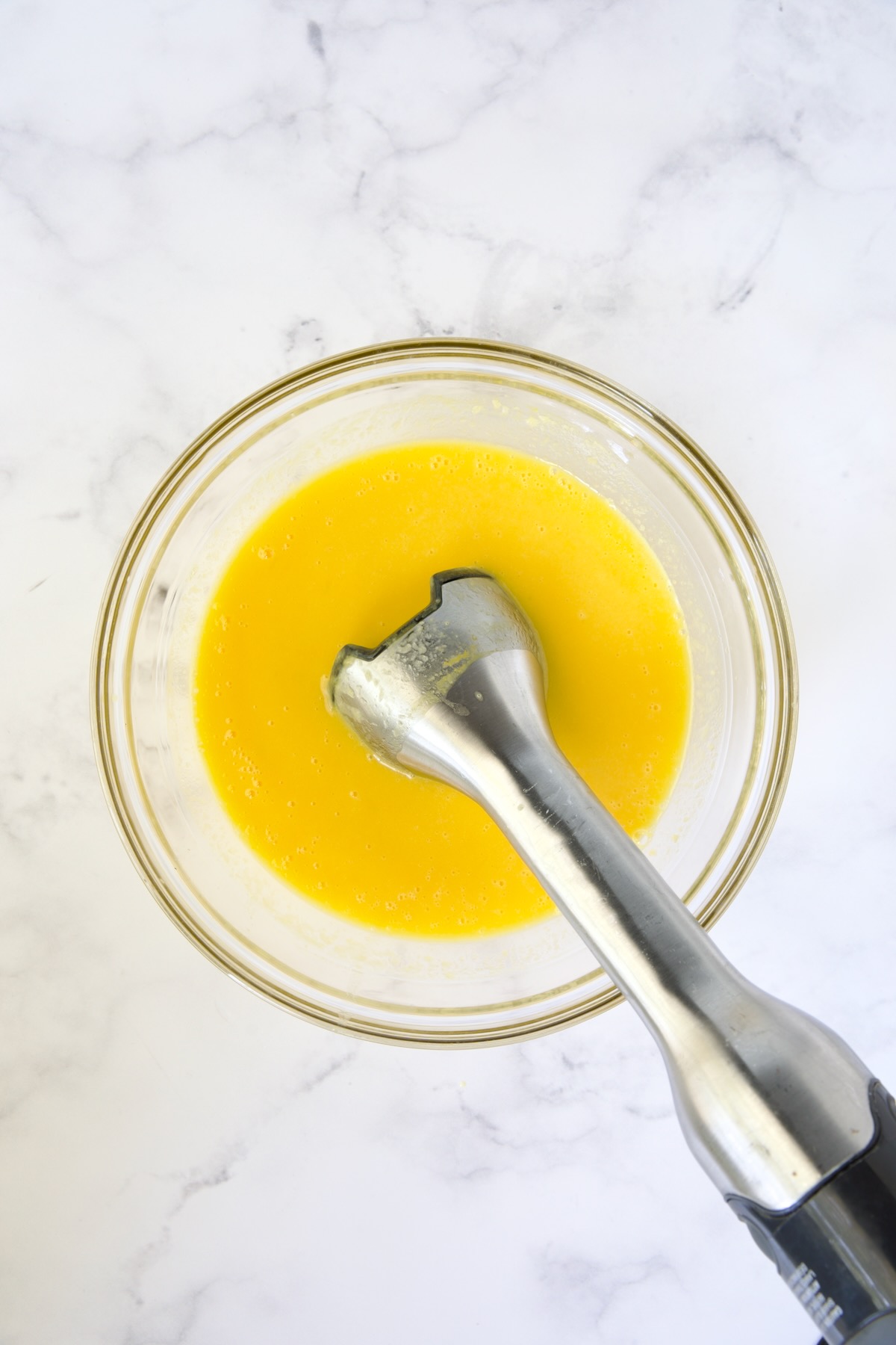 Immersion blender pureeing mango.