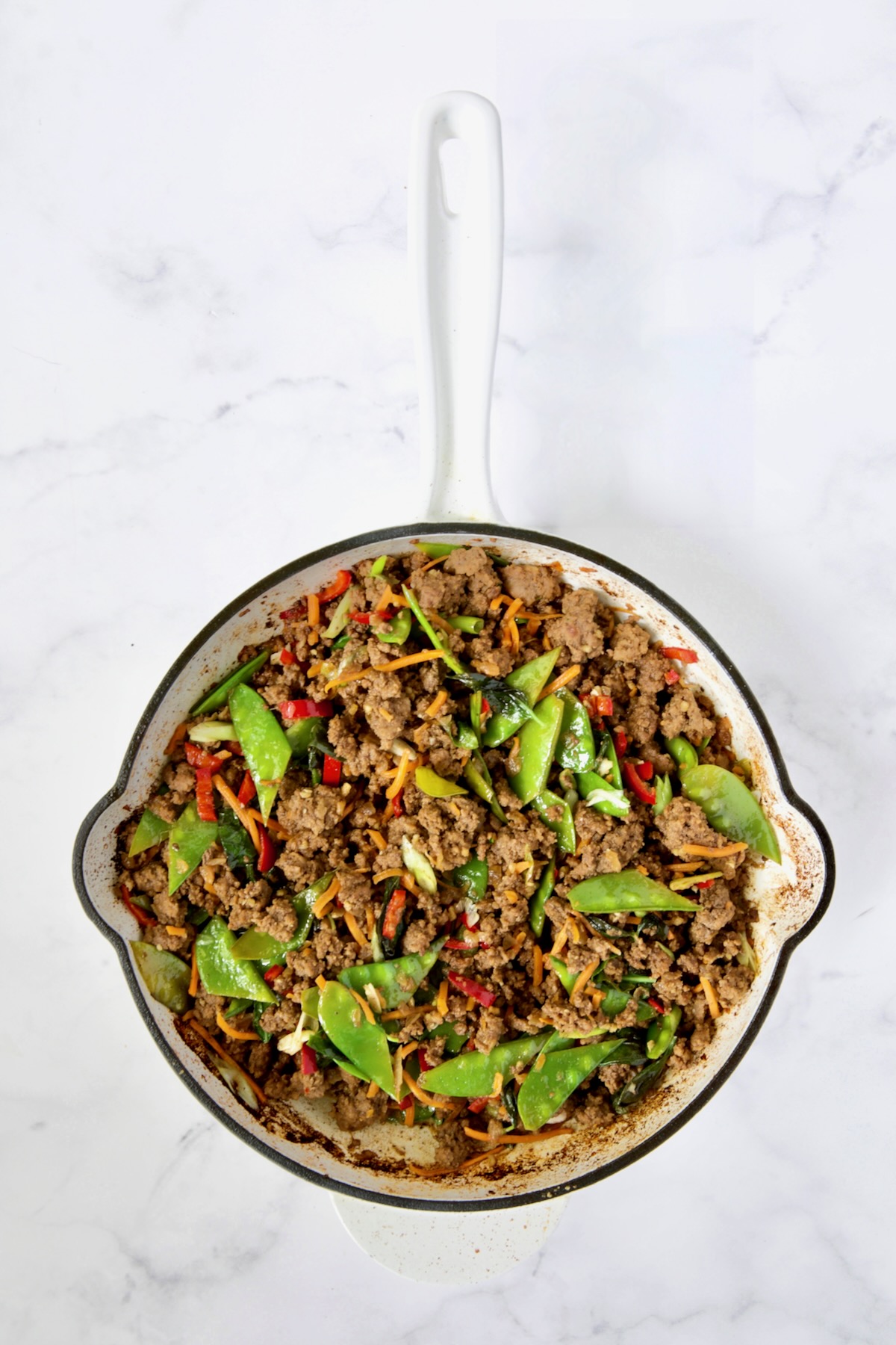 Thai Basil Beef in white enamel cast iron skillet.