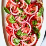 Tomato Onion Salad on white oval platter.