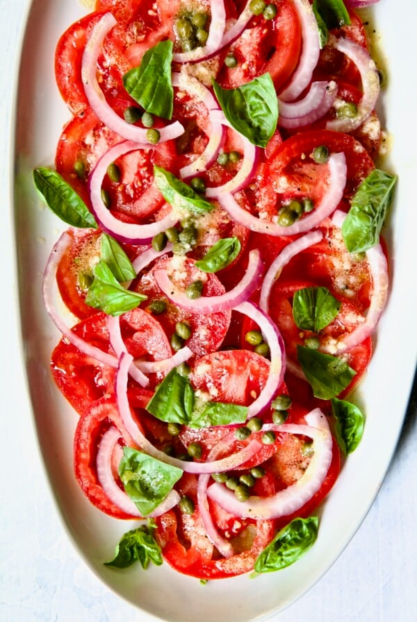 Tomato Onion Salad on white oval platter.