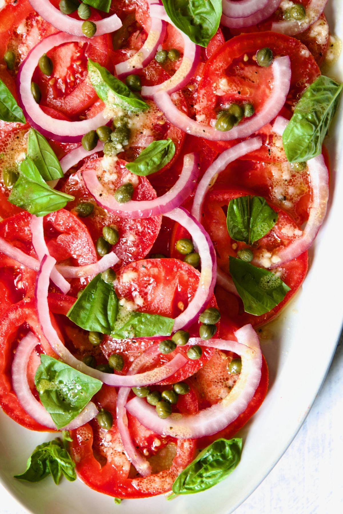 Tomato Onion Salad on white oval platter.