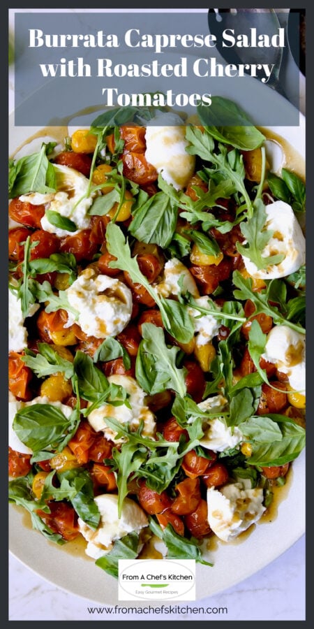 Roasted Cherry Tomato Burrata Caprese Salad on white oval platter with serving utensils.