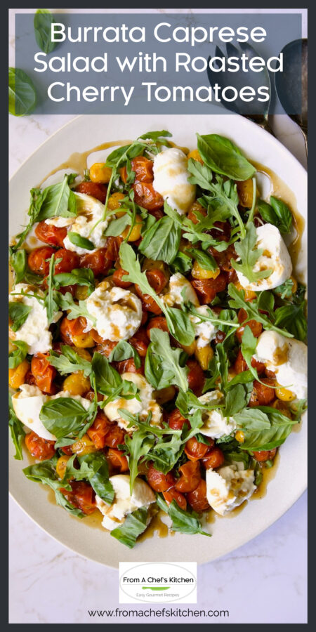 Roasted Cherry Tomato Burrata Caprese Salad on white oval platter with serving utensils.