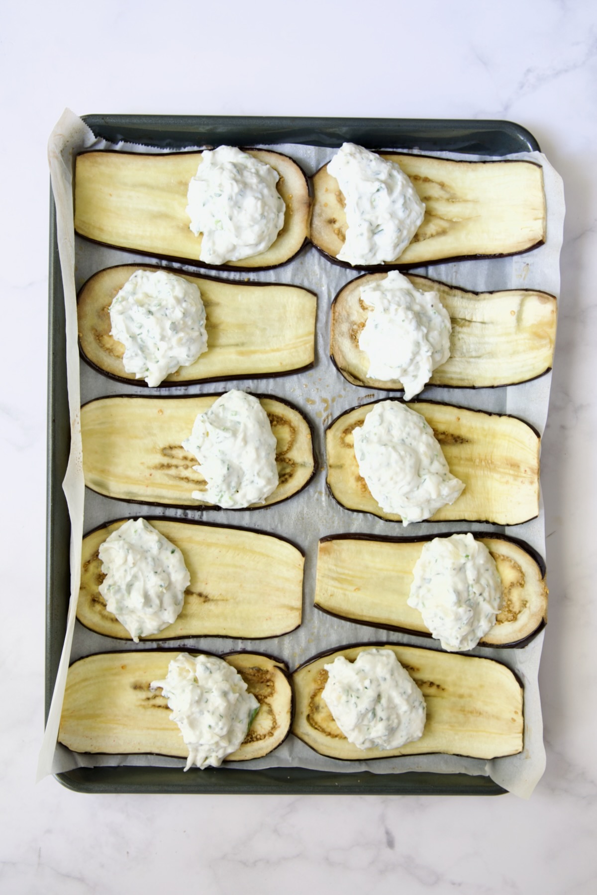 Filling placed on baked eggplant slices before being rolled up.