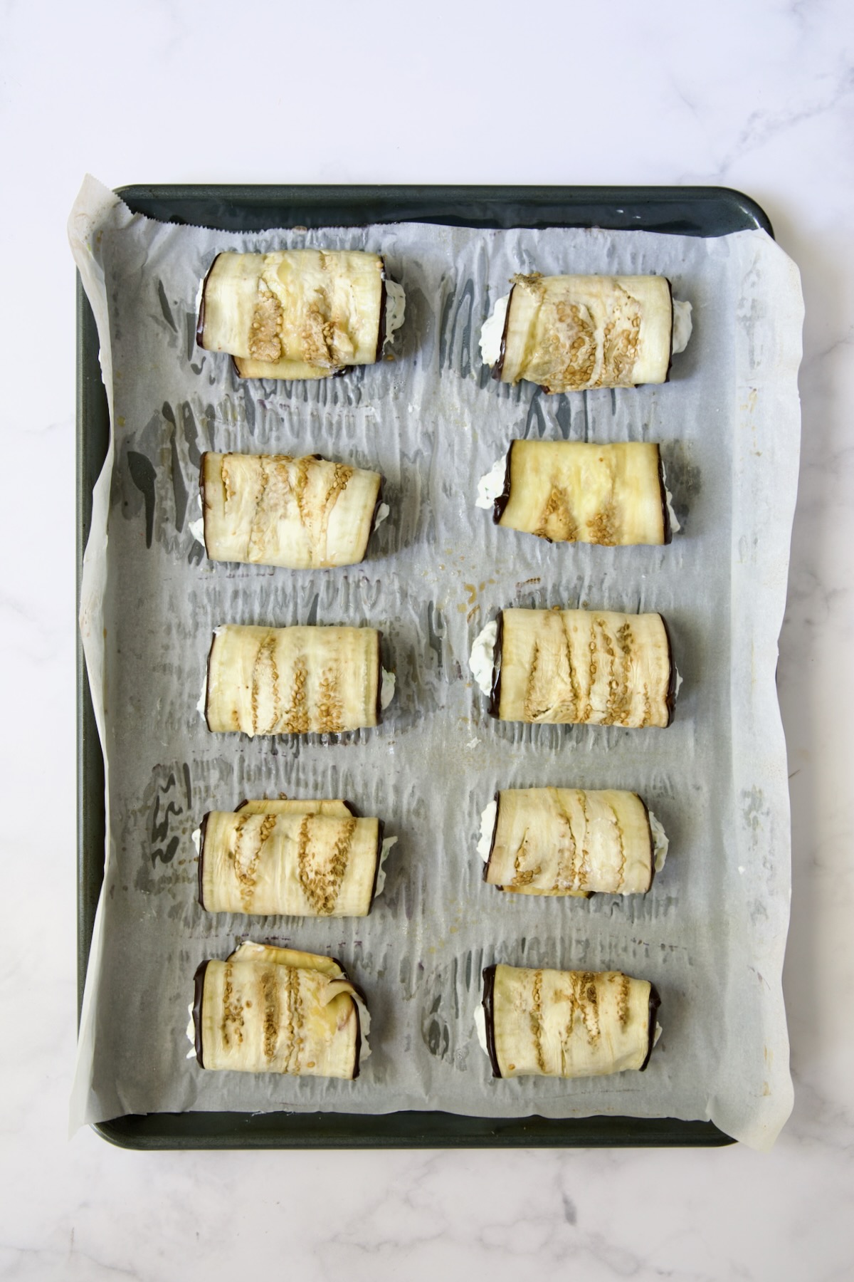 Then cheese-filled eggplant rolls on parchment paper-lined baking sheet.