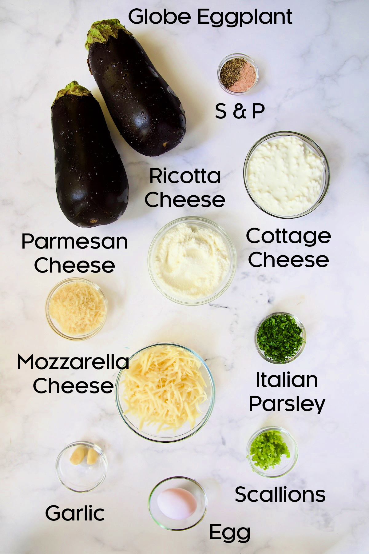Ingredients for the filling for Four-Cheese Eggplant Rollatini in glass bowls on marble countertop.