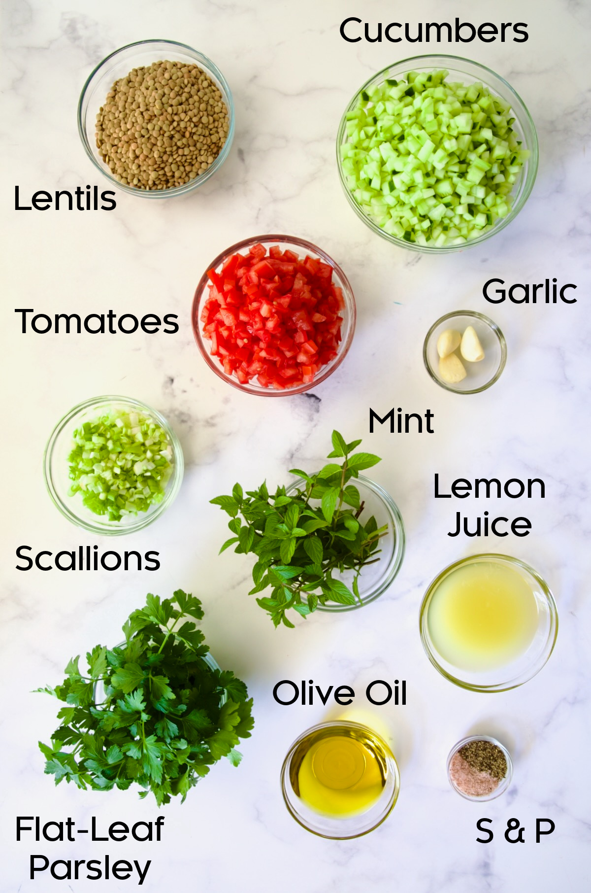 Ingredients for Lentil Tabbouleh in glass bowls on marble countertop.