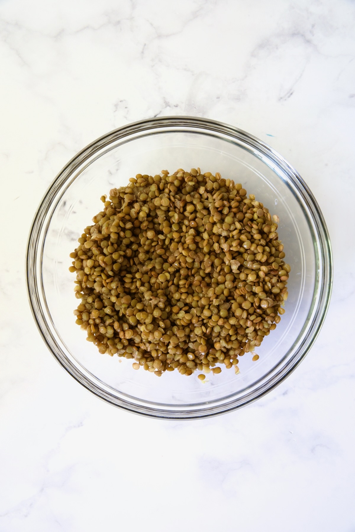 Cooked lentils in glass bowl.