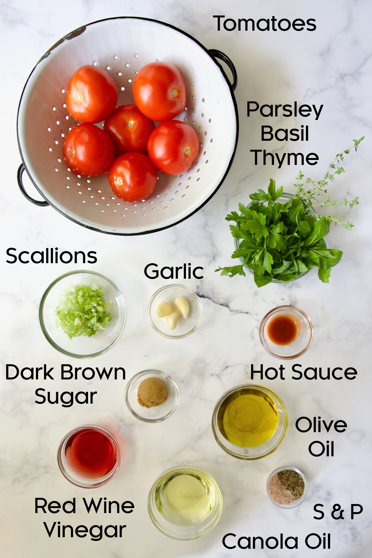 Ingredients for Marinated Tomatoes in glass bowls on marble countertop.