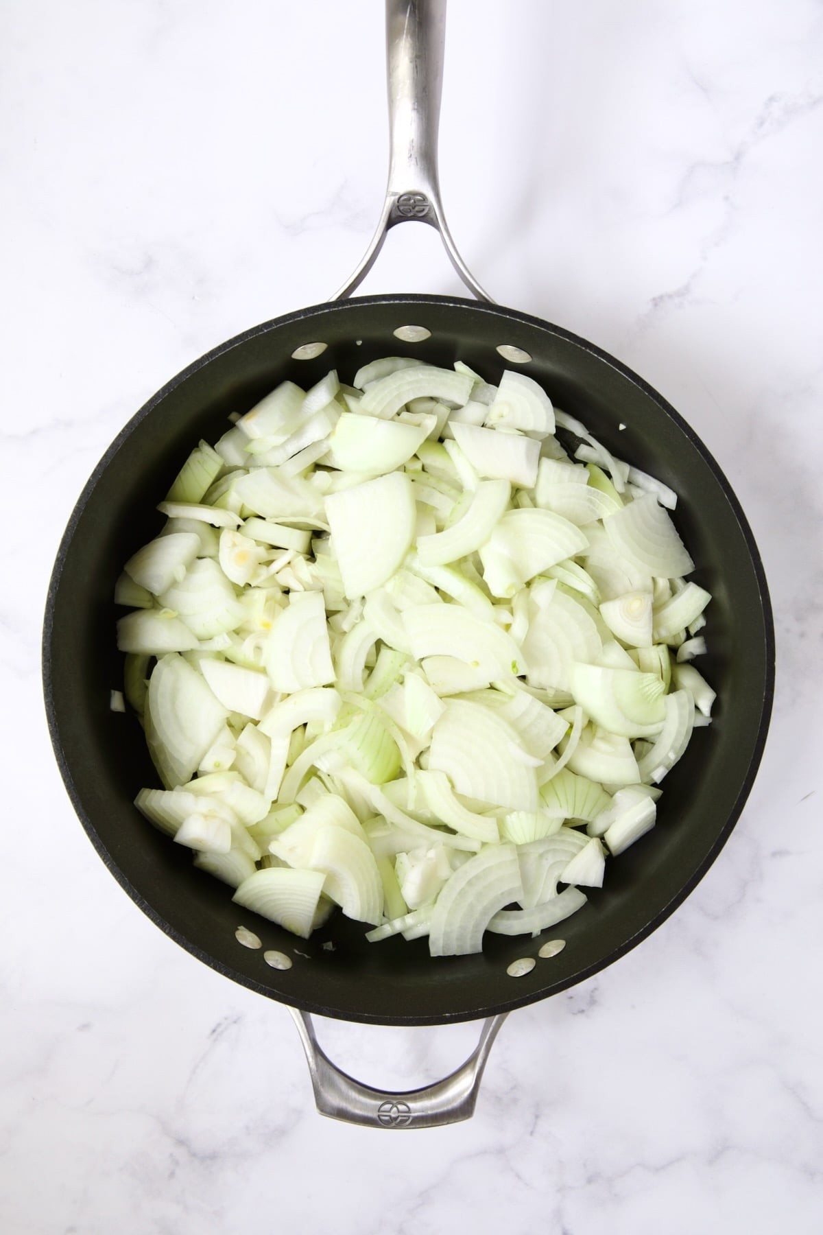Raw onions in nonstick skillet.