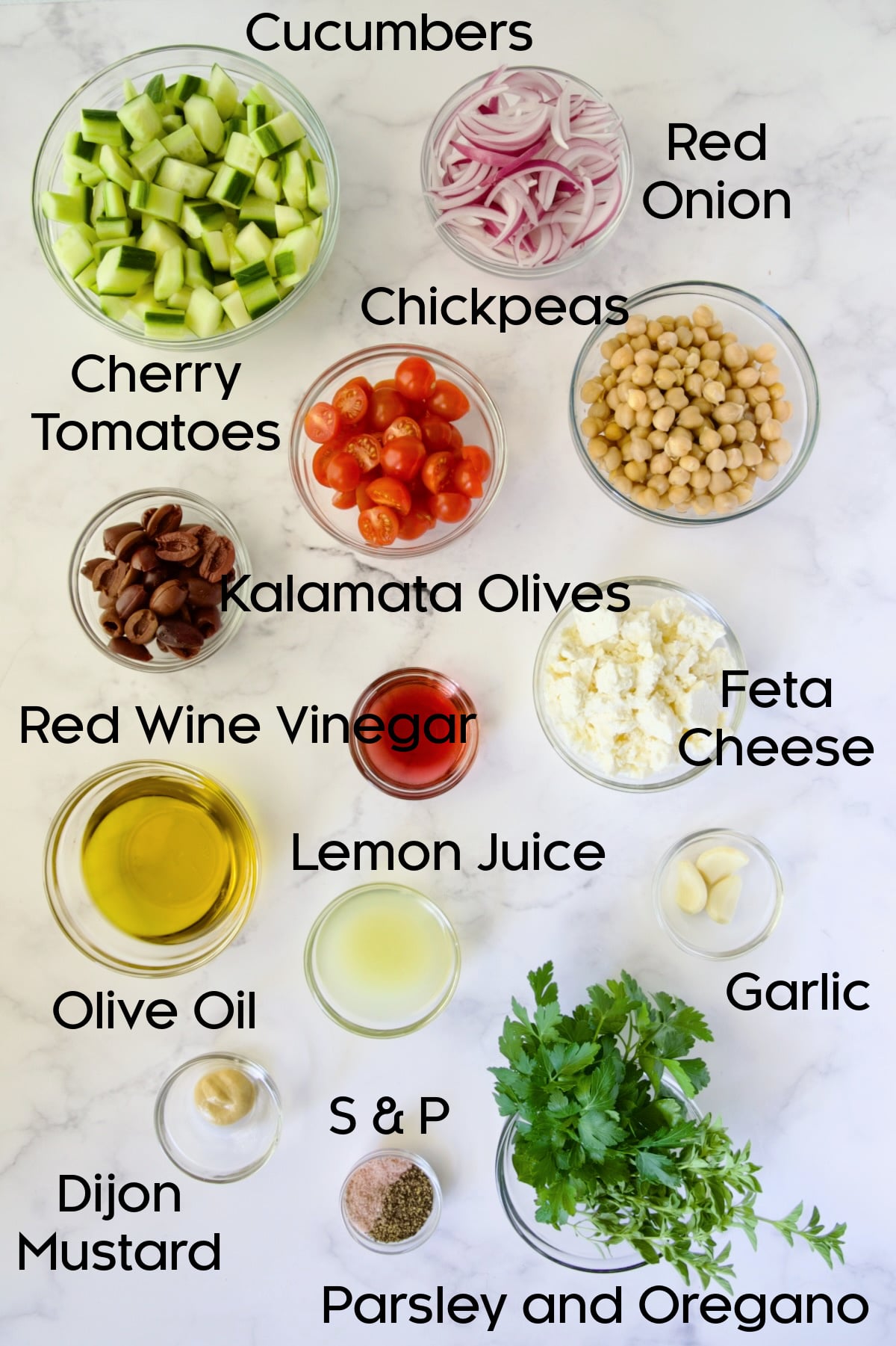Ingredients for Greek Cucumber Salad in separate glass bowls.