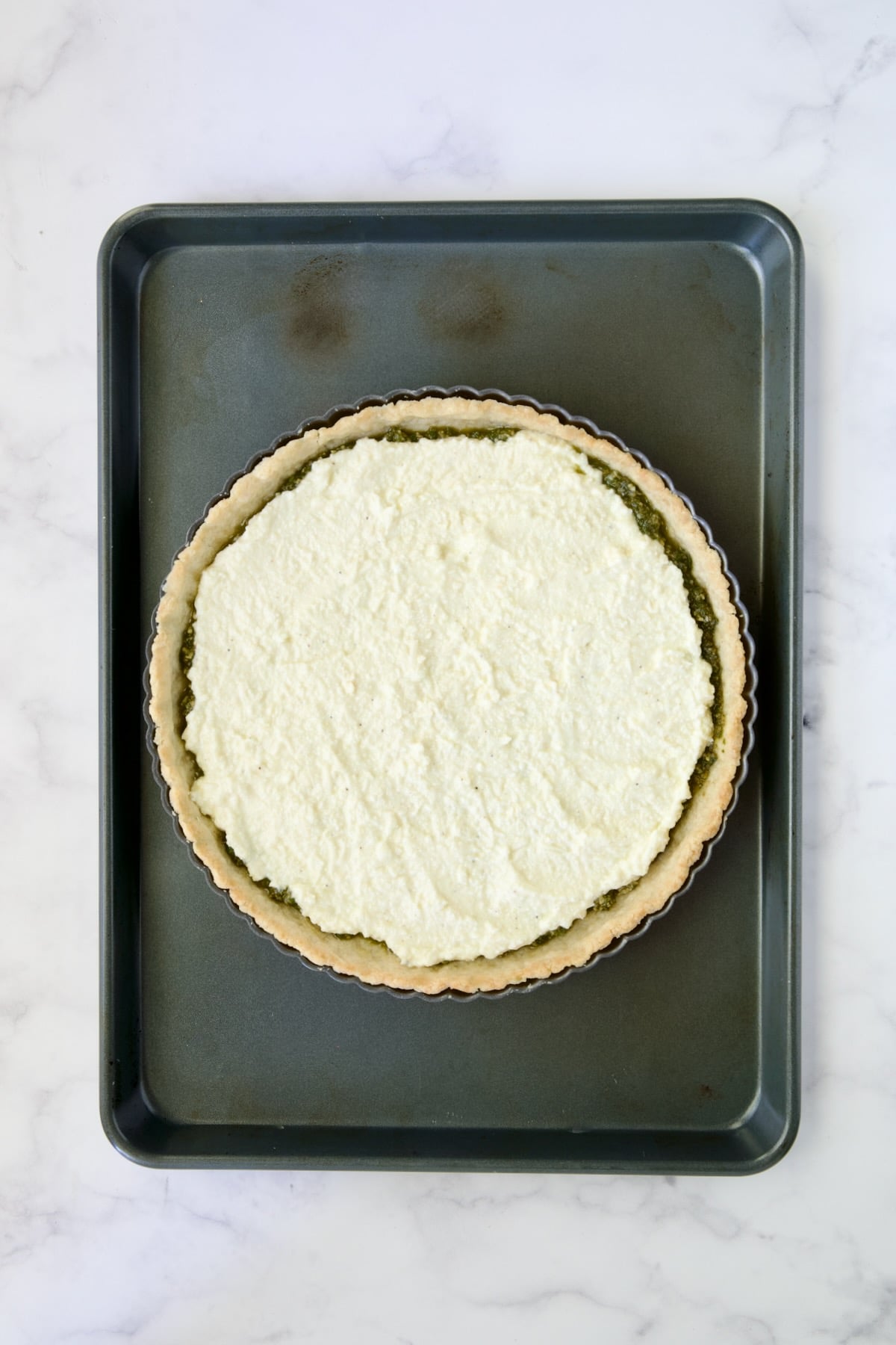 Ricotta custard layer added over pesto.